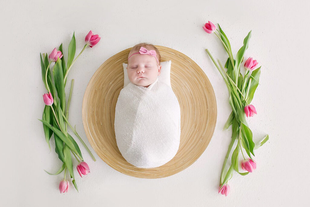 newborn with tulip flowers