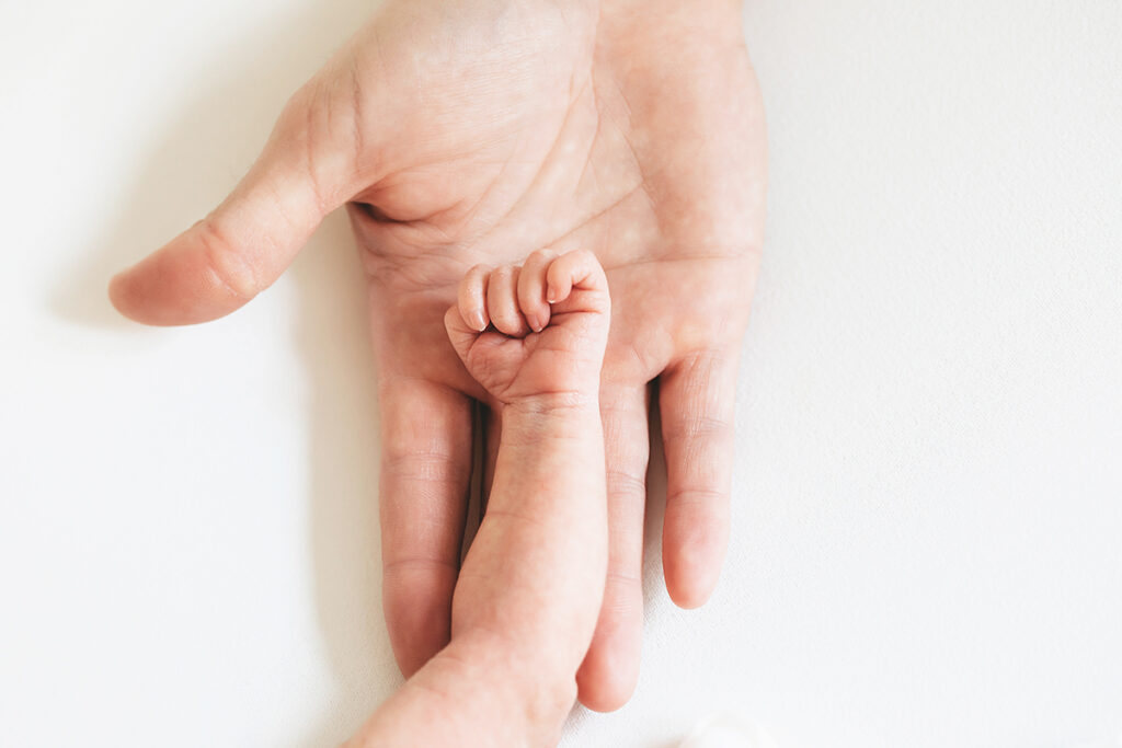 newborn baby hand with dads hand