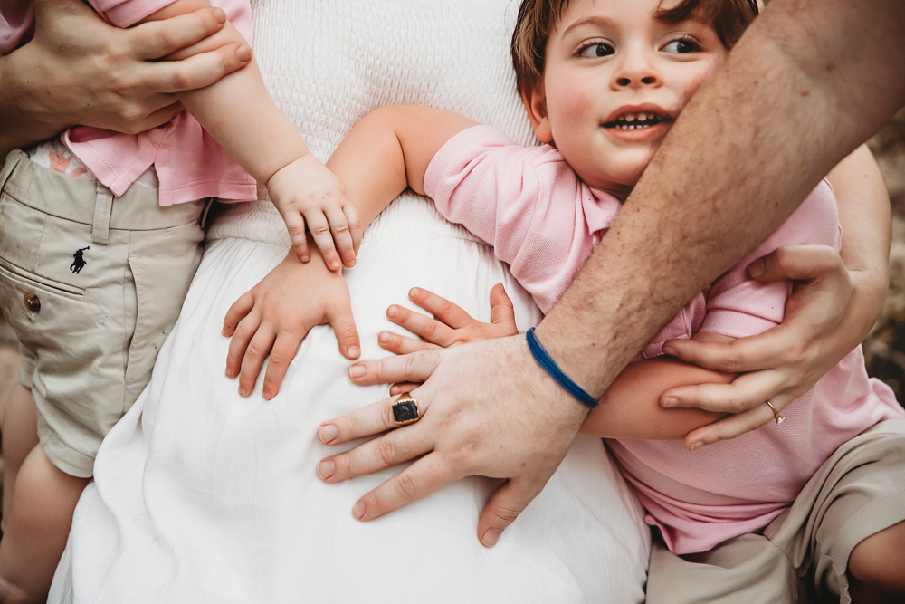 family hands on belly bump