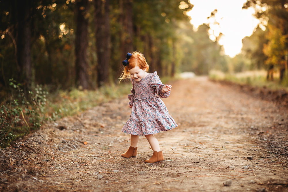 little girl playing on dirt road