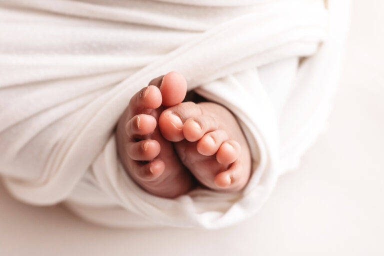 Newborn Lily macro view of both little feet peeking from the swaddle at Reflection Images by Tracy Rowell in Florence SC