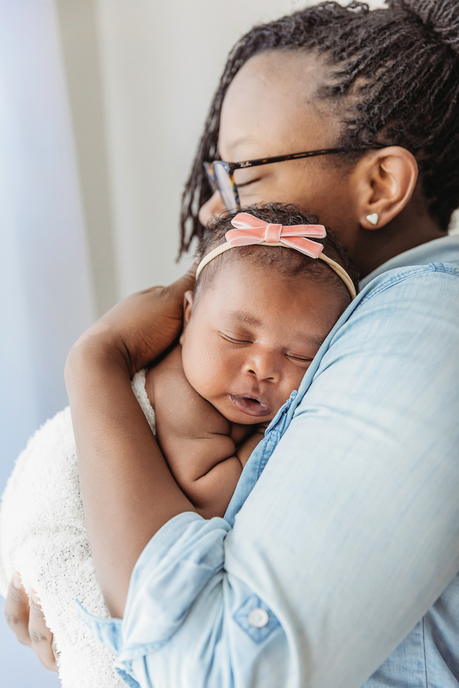 African American newborn Lily snuggled on moms shoulder during a tender cuddle moment at Reflection Images by Tracy Rowell in Florence SC
