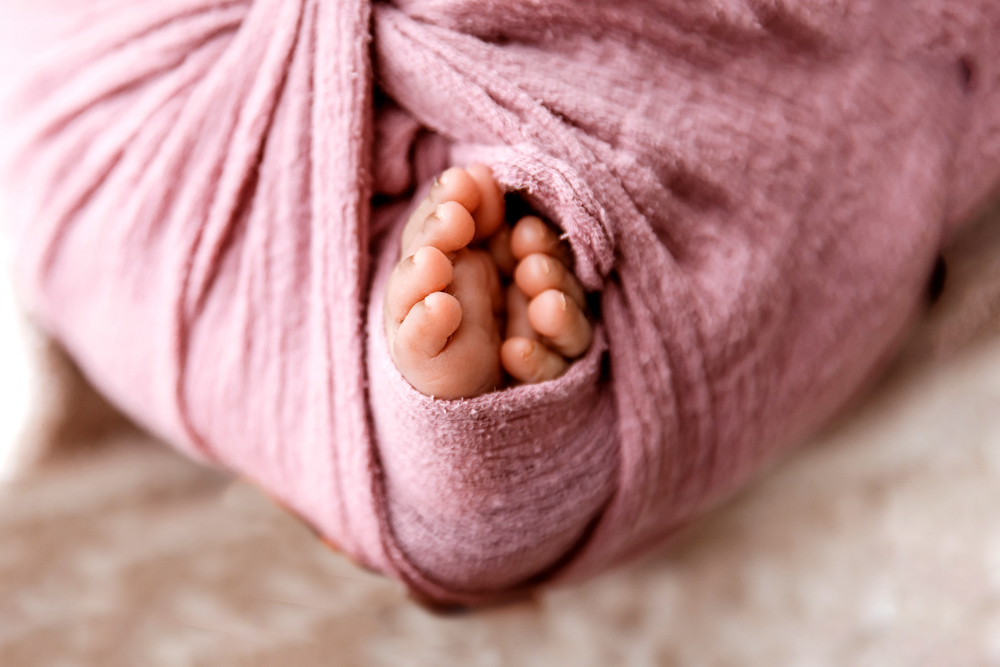 Newborn Lily macro of toes peeking from mauve wrap pocket at Reflection Images by Tracy Rowell in Florence SC