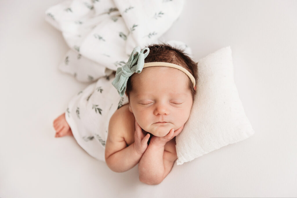 newborn baby sleeping holding face