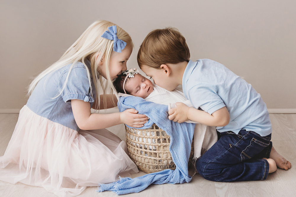 brother and sister kissing baby