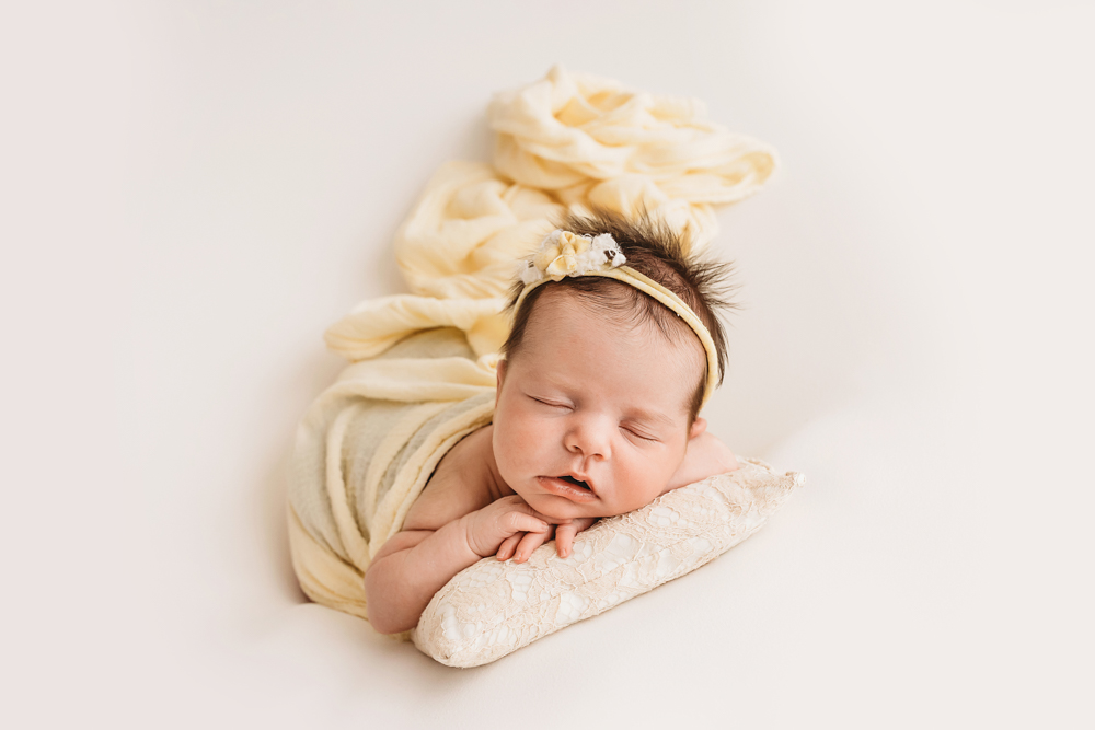 newborn sleeping on pillow