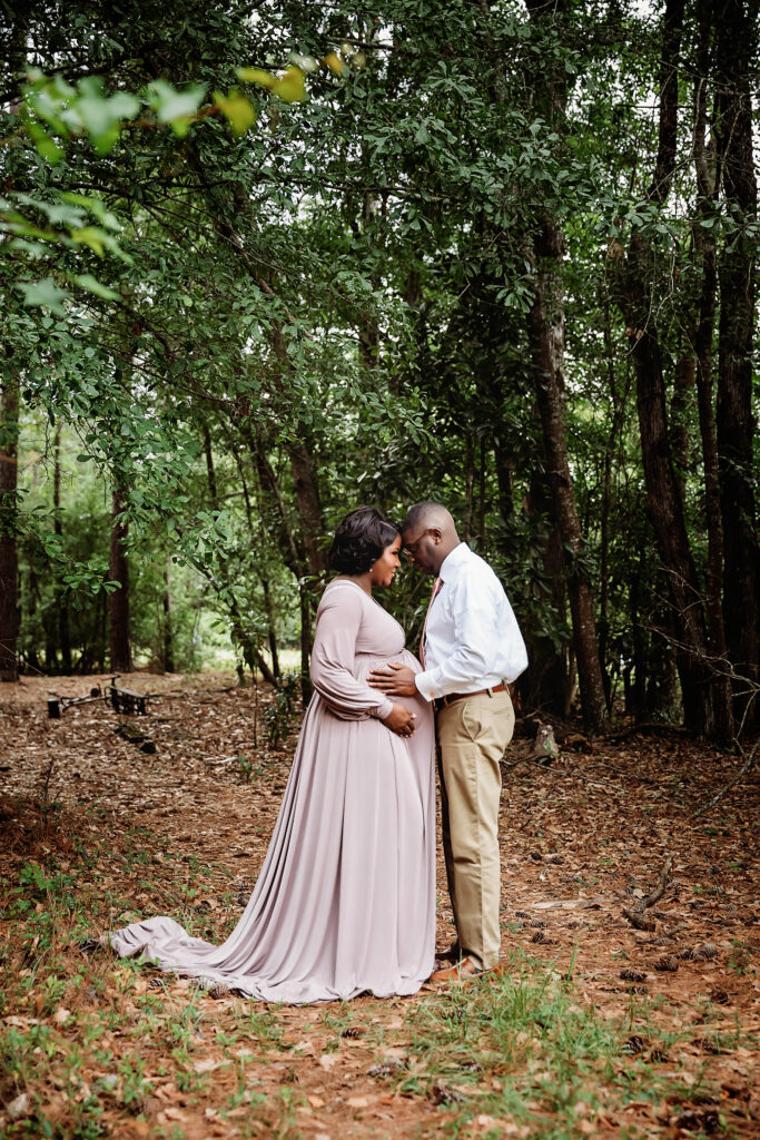 Foreheads together in woods, hand on belly at Reflection Images by Tracy Rowell in Florence SC