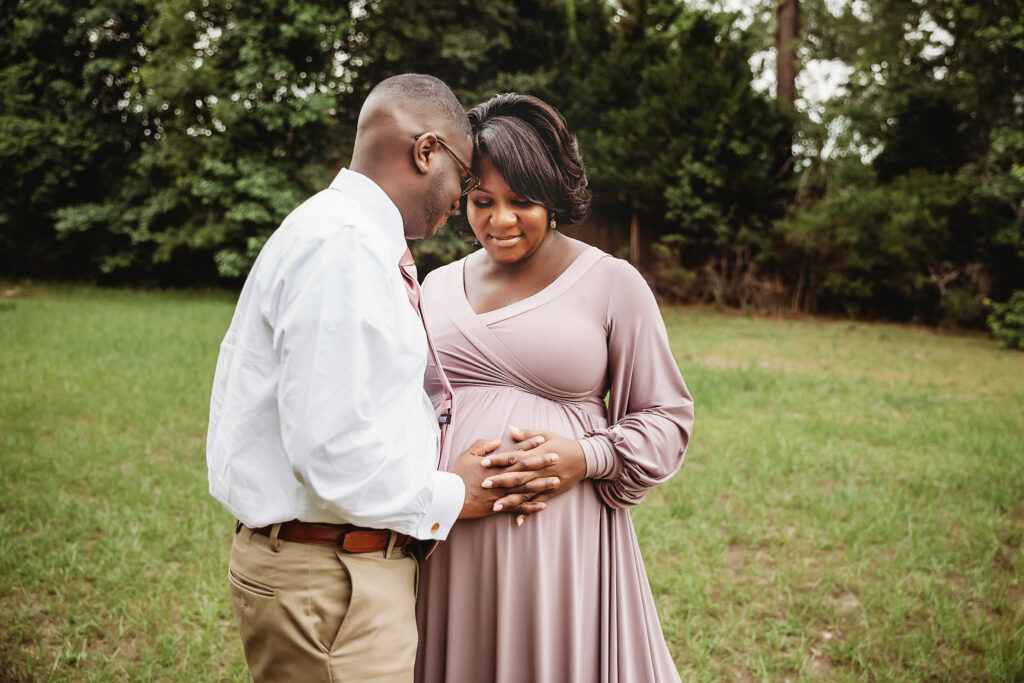 Foreheads together, hands on belly, soft greenery at Reflection Images by Tracy Rowell in Florence SC