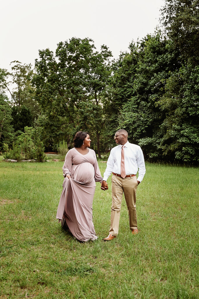 Couple walking together holding hands across the field, relaxed smiles at Reflection Images in Florence SC.
