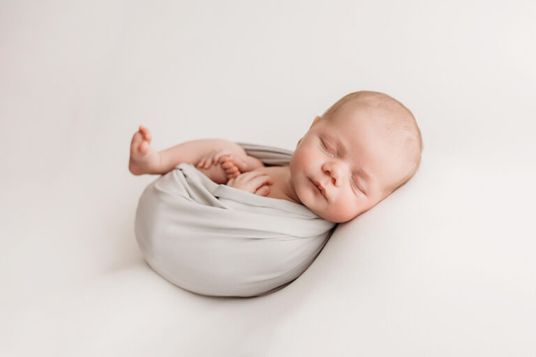 Profile view of swaddled Beau lying on his side in gray wrap with relaxed expression at Reflection Images by Tracy Rowell in Florence SC