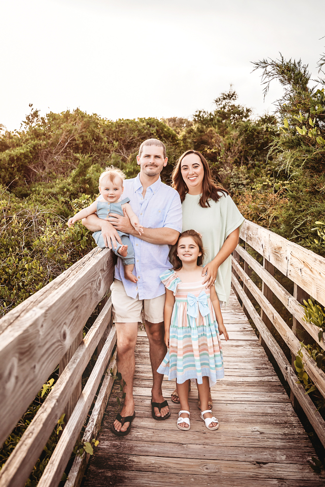 The Skinner family posing together on a boardwalk with summer outfits and soft smiles at Reflection Images by Tracy Rowell in Florence SC
