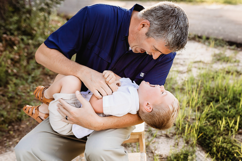 dad lifting boy with natural light, smiles, and love at Reflection Images by Tracy Rowell in Florence SC