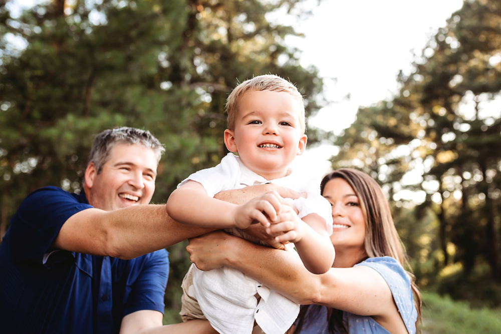 mom dad lift son with natural light, smiles, and love at Reflection Images by Tracy Rowell in Florence SC