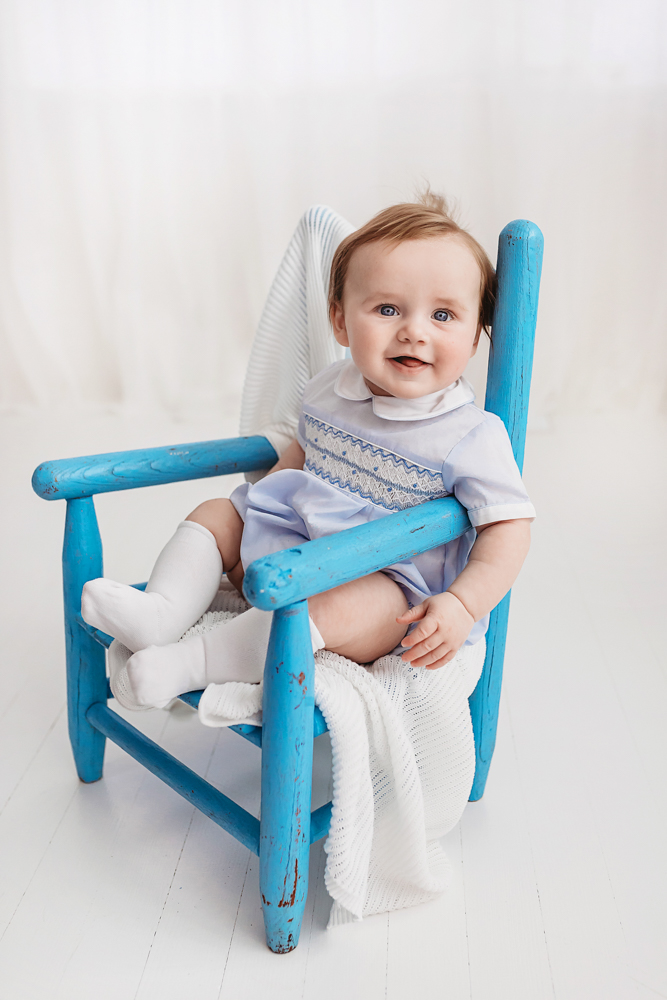 Baby sitting in rustic blue wooden chair with blanket, newborn photographer Florence SC