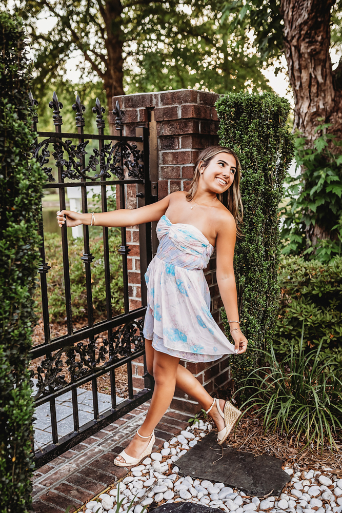wooded park at golden hour, showing a twirling pose in floral dress from a full-body angle at Reflection Images by Tracy Rowell in Florence SC.