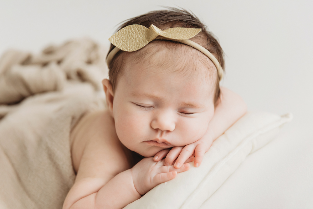Mary Katherine posed on a small pillow with a golden leaf headband and neutral blanket drape at Reflection Images by Tracy Rowell in Florence SC