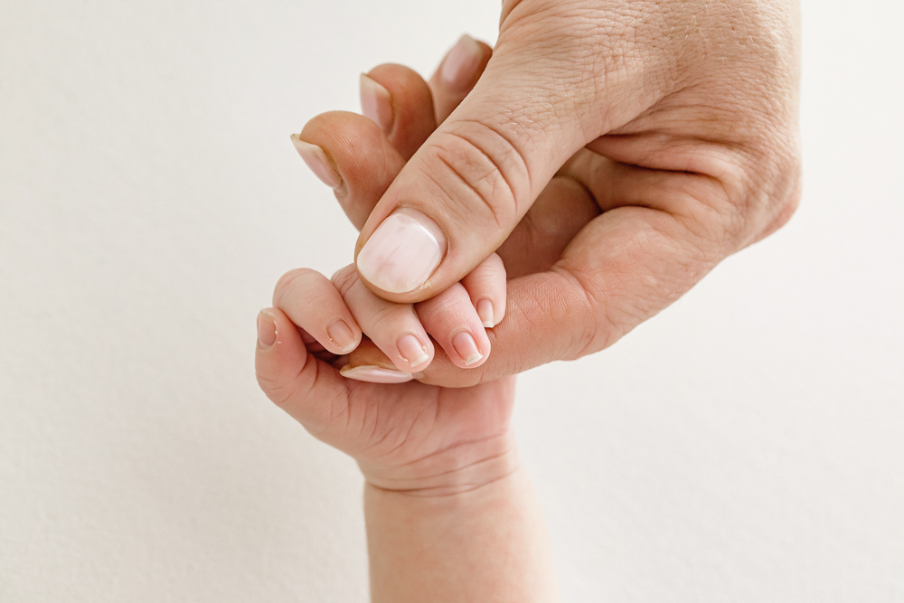 Close-up of newborn Finns tiny hand wrapped around momâ€™s thumb at Reflection Images by Tracy Rowell in Florence SC