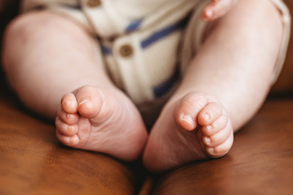 Babys tiny toes resting on leather couch, Reflection Images by Tracy Rowell studio photography