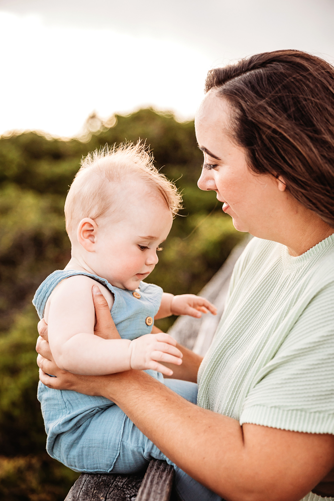 Kristy and baby Cole sharing a tender moment on the boardwalk with soft light and natural surroundings at Reflection Images by Tracy Rowell in Florence SC