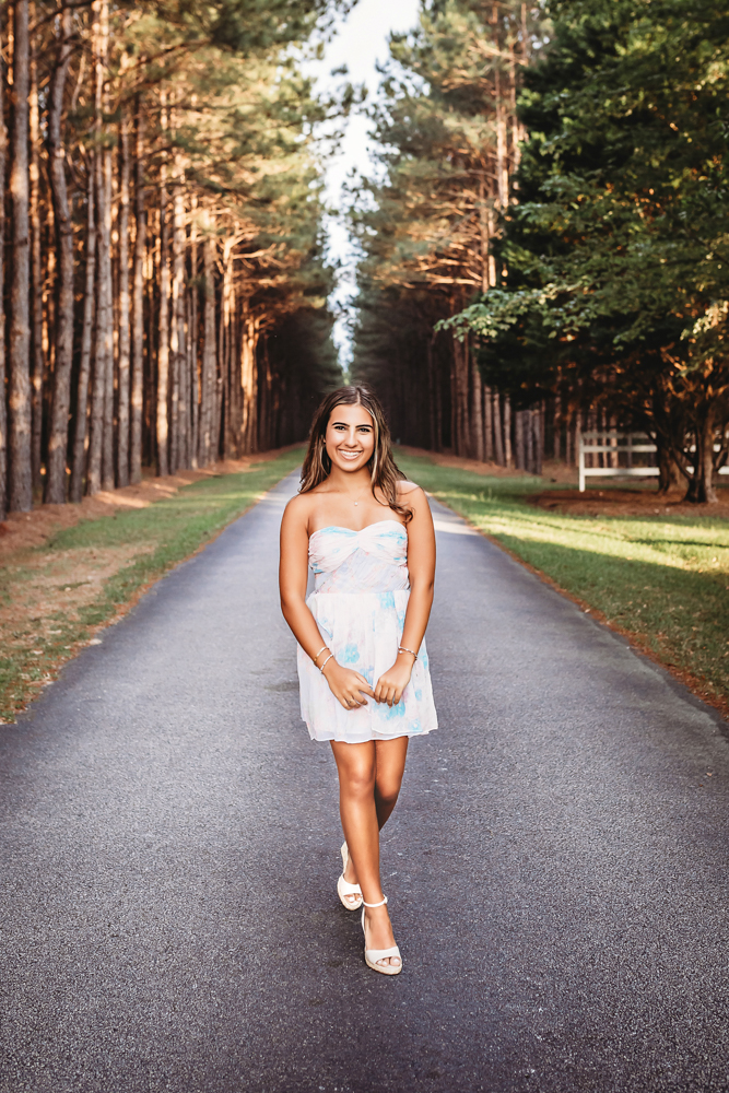 rustic bridge at golden hour, showing a walking pose in floral dress from a full-body angle at Reflection Images by Tracy Rowell in Florence SC.