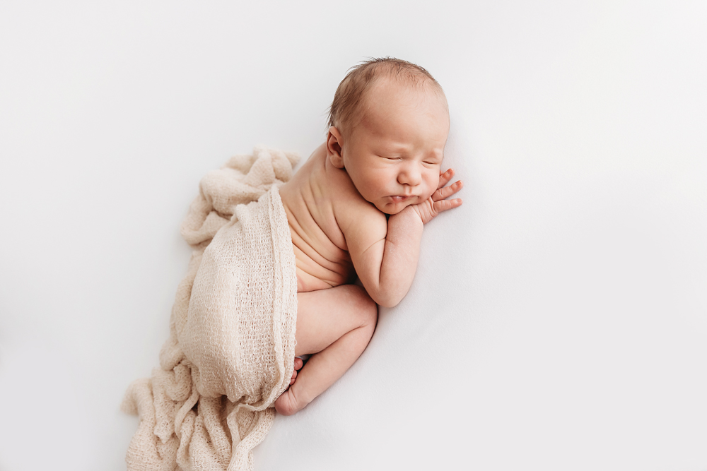 Harry in a loose tan knit wrap posed side-lying with head resting on hand at Reflection Images by Tracy Rowell in Florence SC