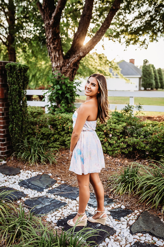 rustic bridge at golden hour, showing a twirling pose in white boots from a over-the-shoulder angle at Reflection Images by Tracy Rowell in Florence SC.