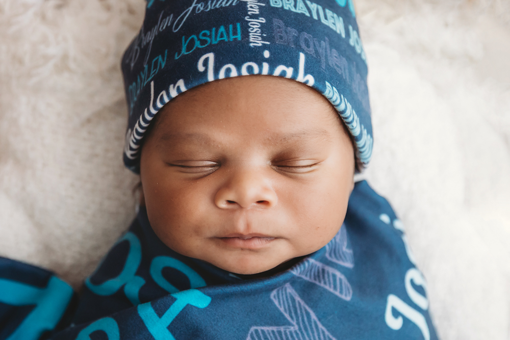 Close-up of Braylen sleeping in custom blue wrap and hat printed with his name at Reflection Images by Tracy Rowell in Florence SC