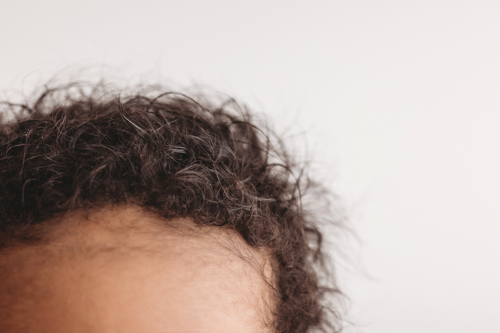 Macro detail of Braylens beautiful curly hair, softly lit with a white studio backdrop at Reflection Images by Tracy Rowell in Florence SC