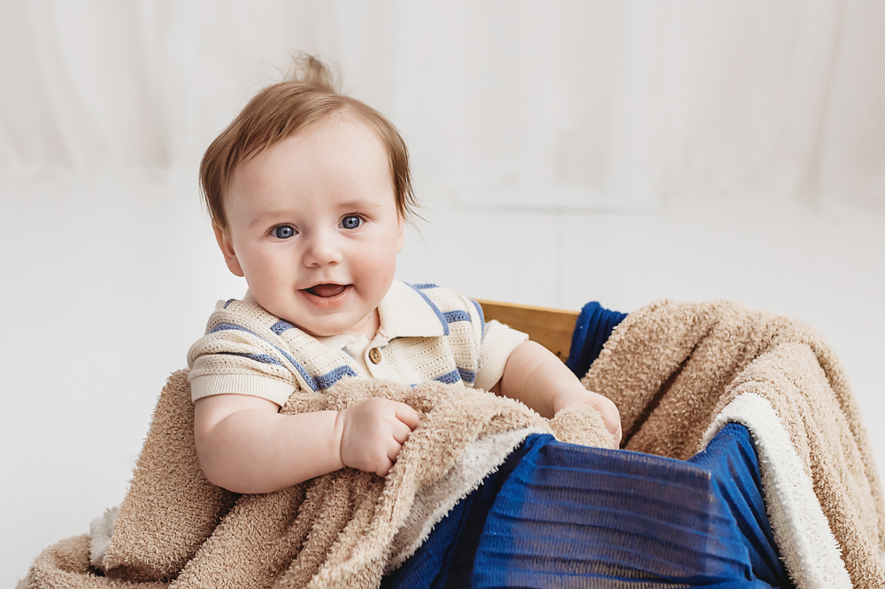 Smiling baby in basket during milestone session, professional photography Florence SC