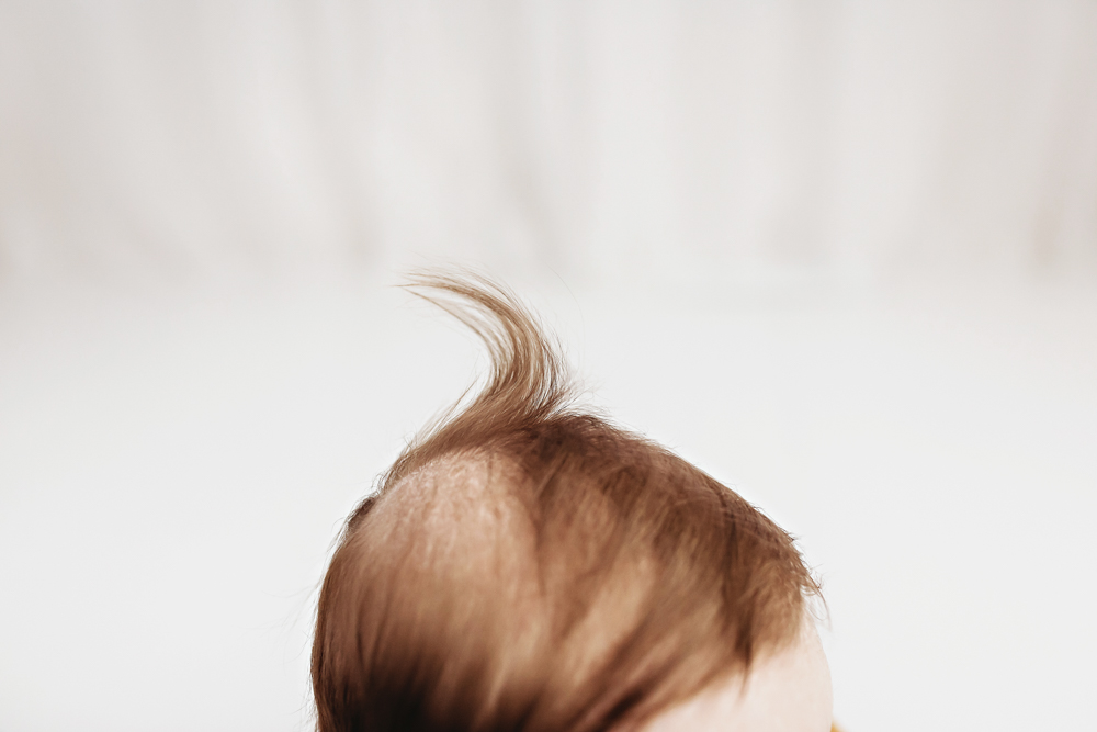 Close-up of babys hair curl in studio light, newborn photographer near Florence SC