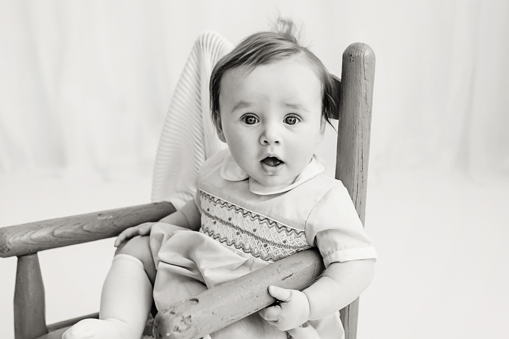 Black and white portrait of baby in blue chair, milestone photographer Florence SC
