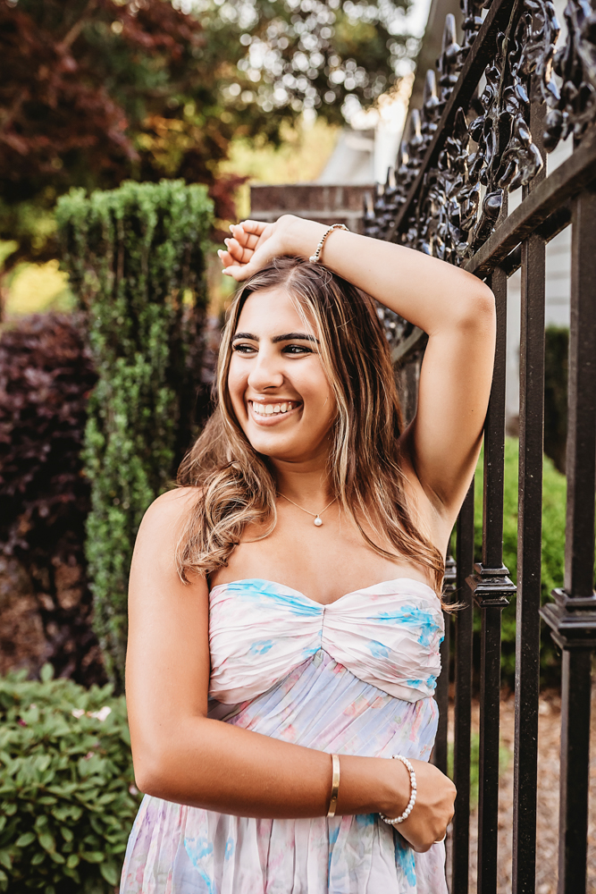 Senior session photo taken in gravel path at golden hour, showing a smiling pose in Gamecock flag from a profile angle