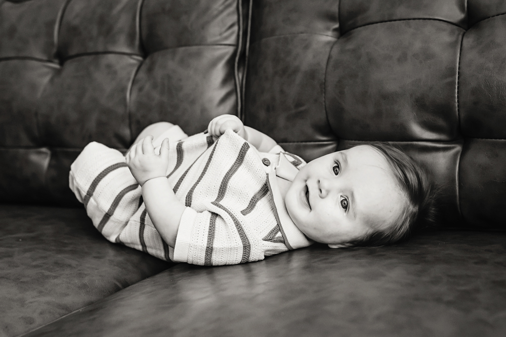 Baby lying on couch in relaxed pose, milestone photographer near Florence SC