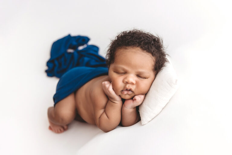 Tight headshot of Braylen with closed eyes, soft curls, and folded hands under chin on white background at Reflection Images by Tracy Rowell in Florence SC