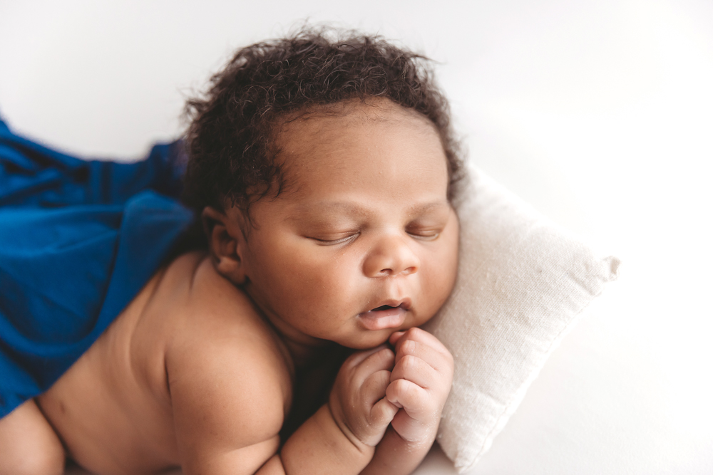 Newborn baby Braylen wrapped in love, surrounded by the hands of his entire family