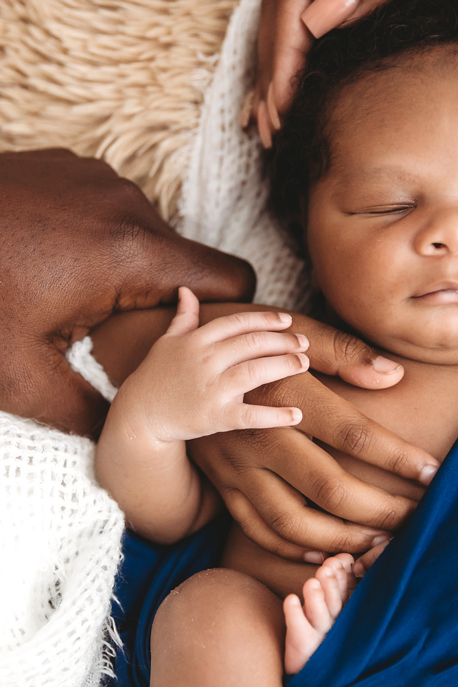 Big brother and family surrounding newborn Braylen with love and hands