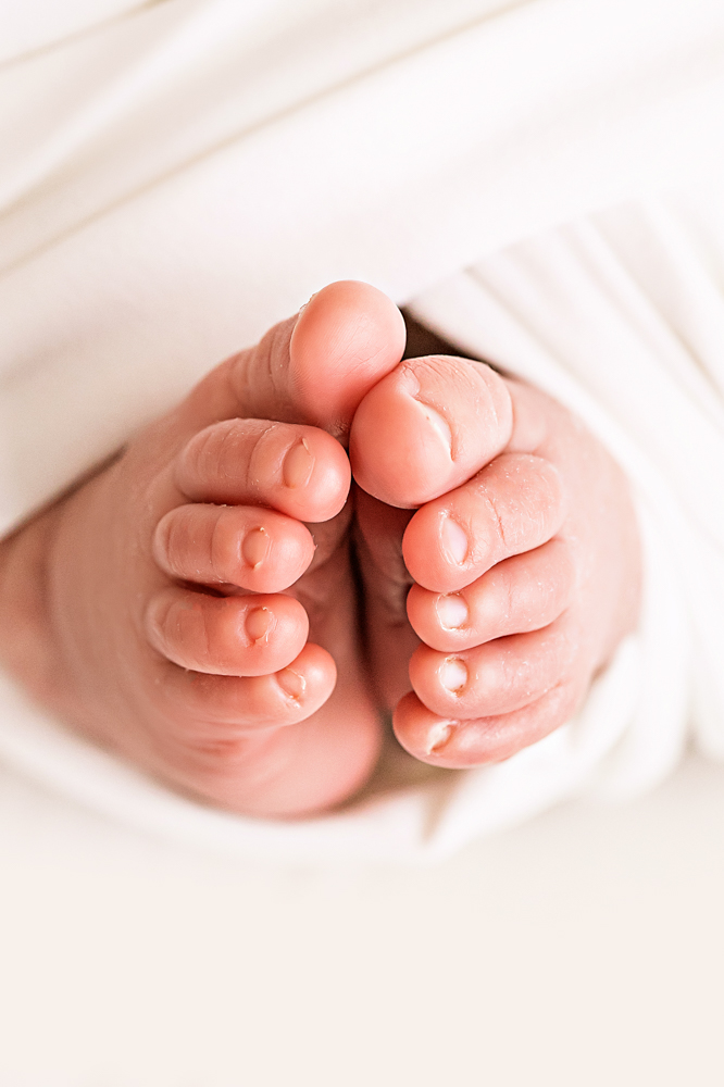 macro of newborn toes peeking from white swaddle Florence SC