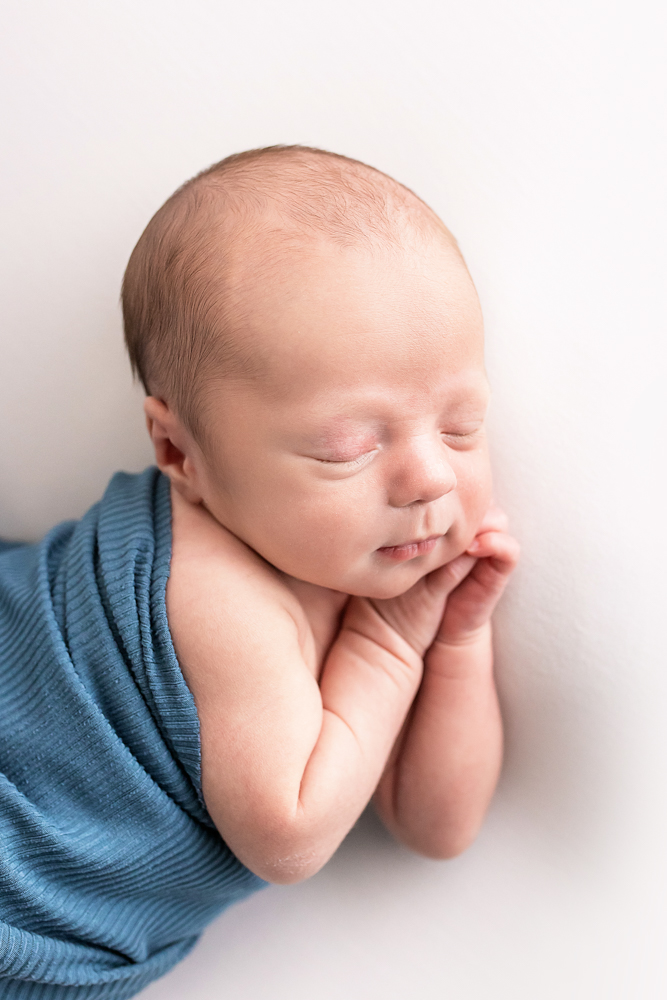 close-up newborn Walker sleeping in teal ribbed wrap against white Florence SC