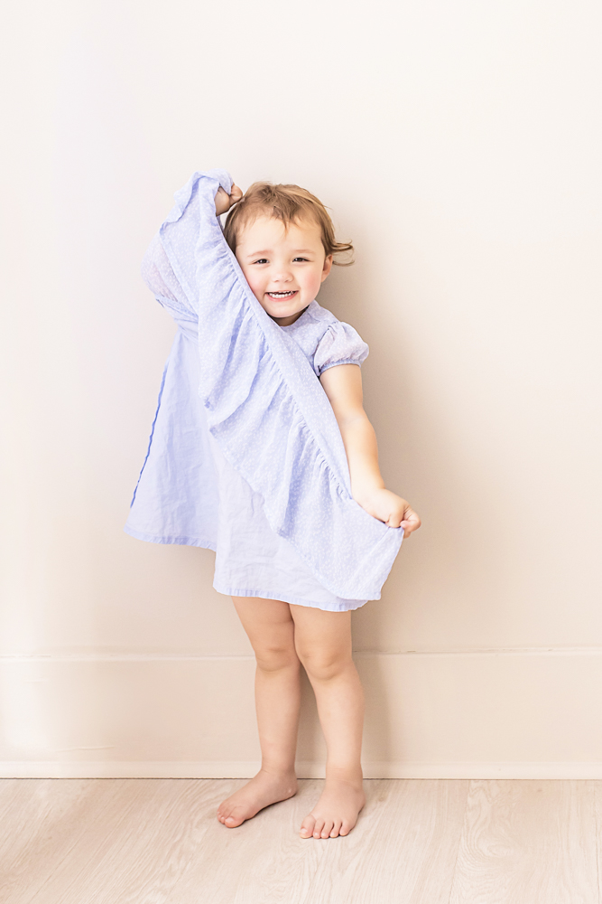 toddler sister playful pose lifting dress smiling at camera Florence SC