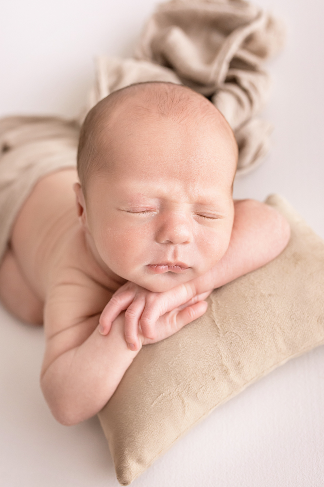 from-above chin-up pose newborn Walker with tan fabrics and mini pillow Florence SC