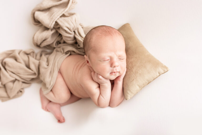 from-above chin-up pose newborn Walker with tan fabrics and mini pillow Reflection Images Florence SC