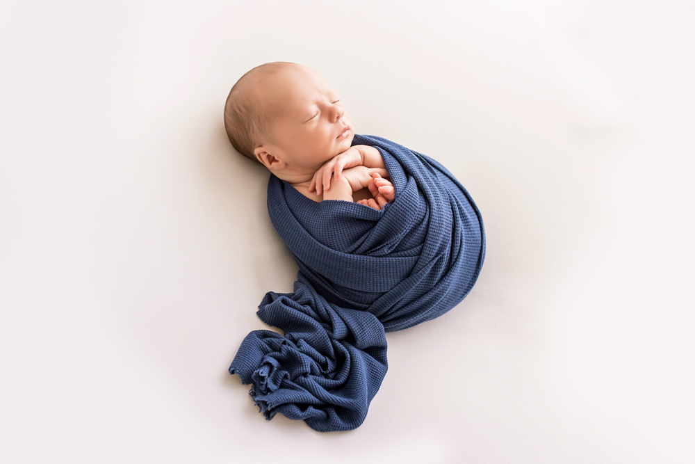 side profile of newborn Walker in navy waffle wrap on white backdrop Florence SC