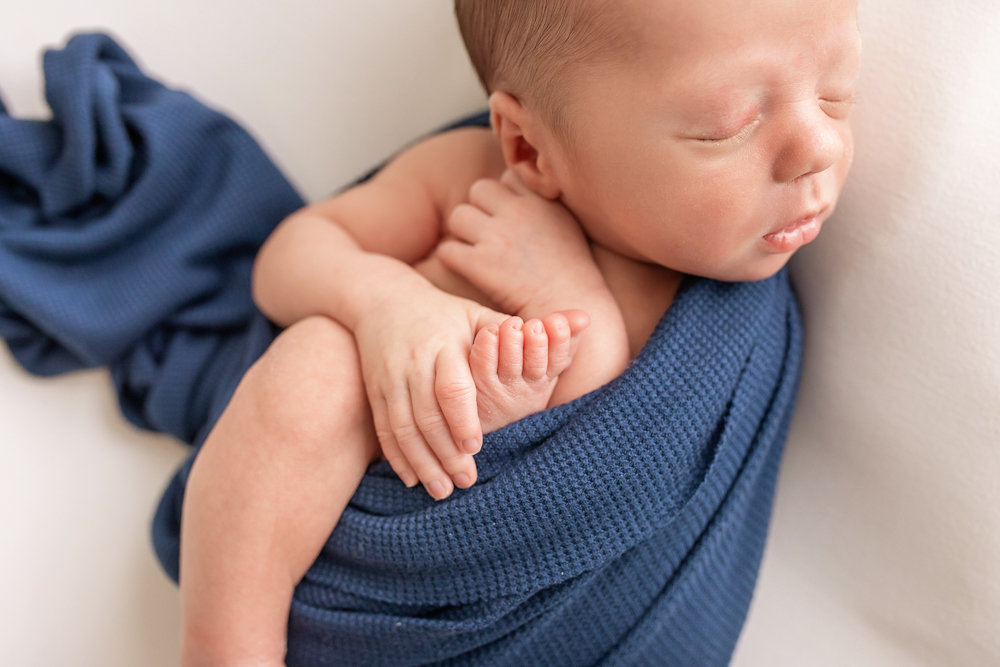 close-up of newborn toes and fingers in navy wrap textured fabric Florence SC Tracy Rowell photography