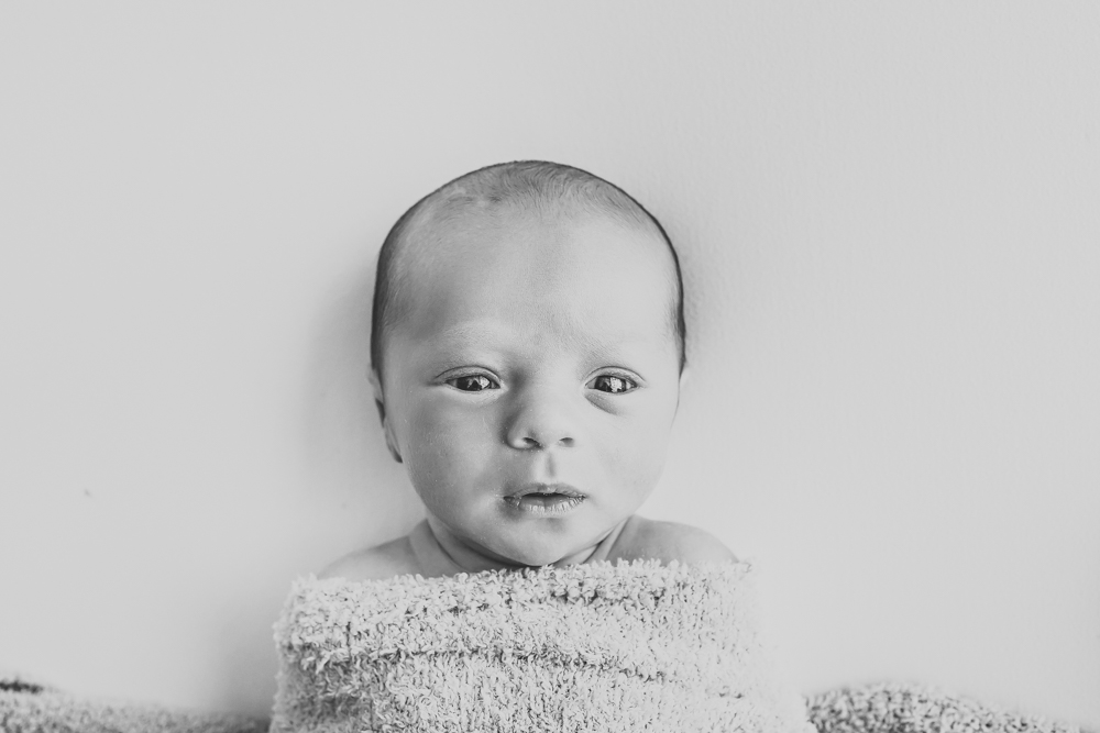black and white portrait newborn Walker wrapped in textured towel looking toward camera Florence SC studio