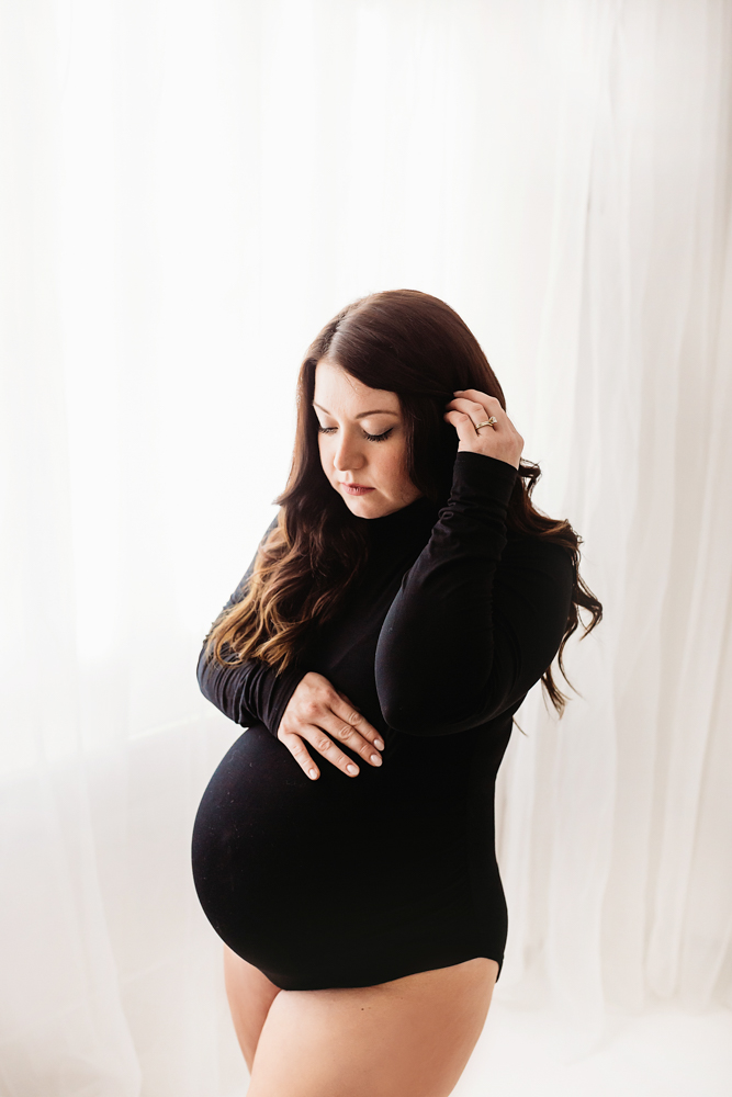 Buenrostro maternity black bodysuit soft in bright natural light and clean studio backdrop at Reflection Images by Tracy Rowell in Florence SC