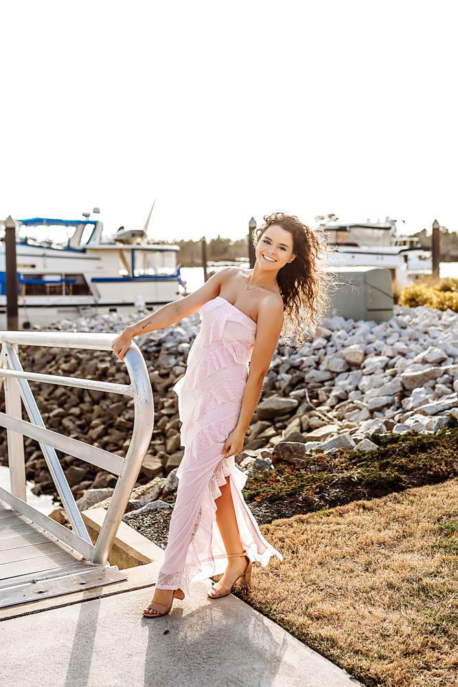 hayden leaning away from waterfront railing with golden hour hair curls Georgetown SC