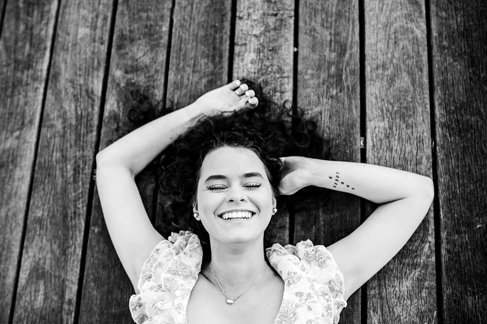 black and white hayden laying on pier boardwalk laughing