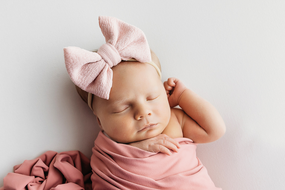 Millie Jo in pink wrap with oversized bow, sleeping peacefully at Reflection Images by Tracy Rowell in Florence SC