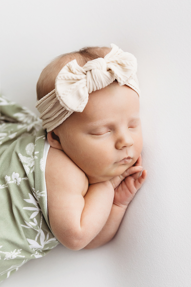 Profile of Millie Jo wrapped in sage floral with her hands tucked under chin at Reflection Images by Tracy Rowell in Florence SC