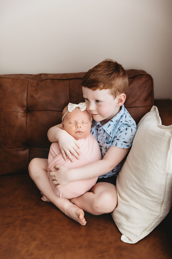 Brother and Millie Jo sharing a sweet snuggle on the couch at Reflection Images by Tracy Rowell in Florence SC